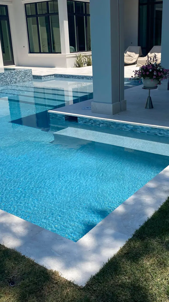 Pool deck with step pads across a turquoise pool